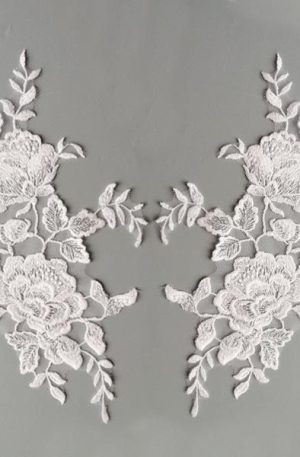 Fehér színű, tüll alapú, dúsan hímzett páros csipke. Szolid, apró átlátszó flitterekkel díszítve