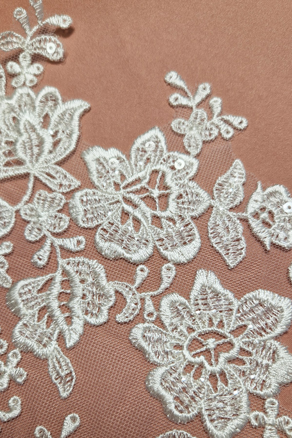 06-1328 törtfehér virágmintás páros csipke, nagyobb központi virágokkal, apró levelekkel és átlátszó flitterekkel, 17 × 30,5 cm.