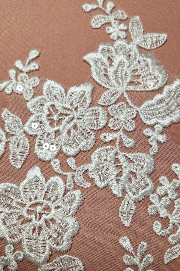 06-1328 törtfehér virágmintás páros csipke, nagyobb központi virágokkal, apró levelekkel és átlátszó flitterekkel, 17 × 30,5 cm.