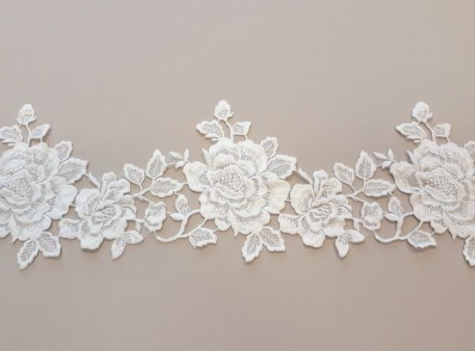 Krém színű, organza alapú, dúsan hímzett szegő csipke.