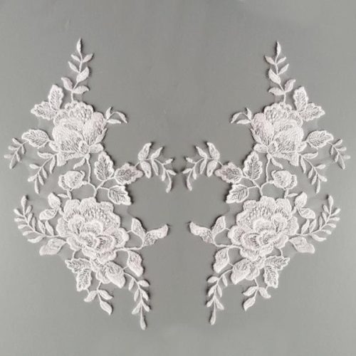 Fehér színű, tüll alapú, dúsan hímzett páros csipke. Szolid, apró átlátszó flitterekkel díszítve