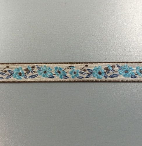 Bézs, kék és barna mintás szalag, egy színoldalú.

Szélessége: 1,2 cm